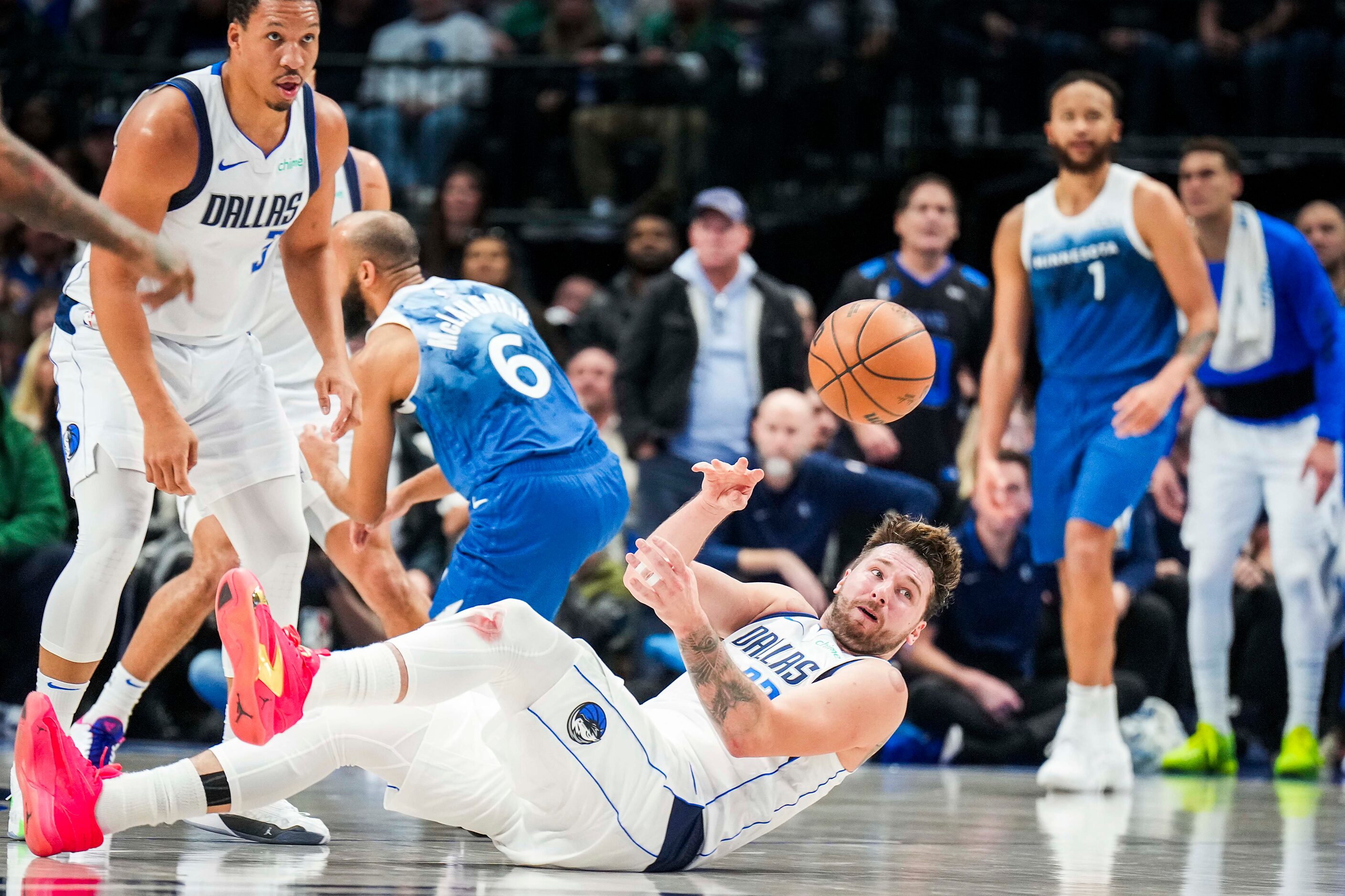 Dallas Mavericks guard Luka Doncic (77) passes the ball from the floor after scooping up a...