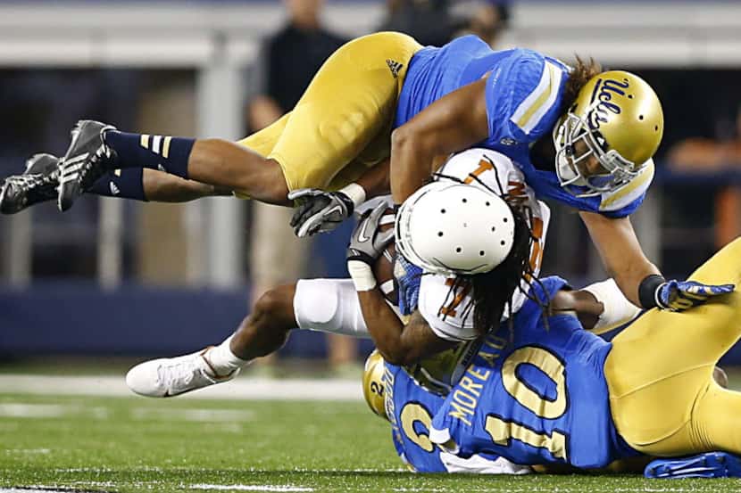 Texas Longhorns wide receiver Marcus Johnson (7) is tackled by UCLA Bruins defensive back...