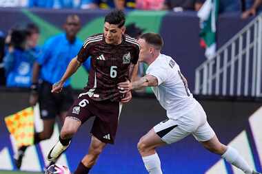 El defensa de la selección mexicana, Gerardo Arteaga (izq) controla el balon ante la presión...