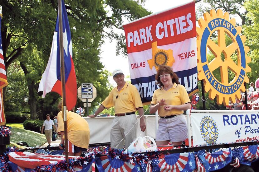 Rick Amsberry (left) rides on a float with his wife, Lisa, in the Rotary Club of Park Cities...