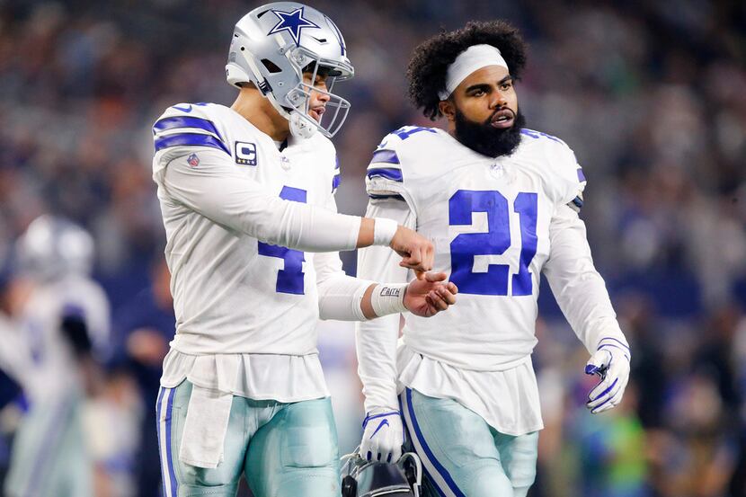 Dallas Cowboys quarterback Dak Prescott (4) discusses a play with running back Ezekiel...
