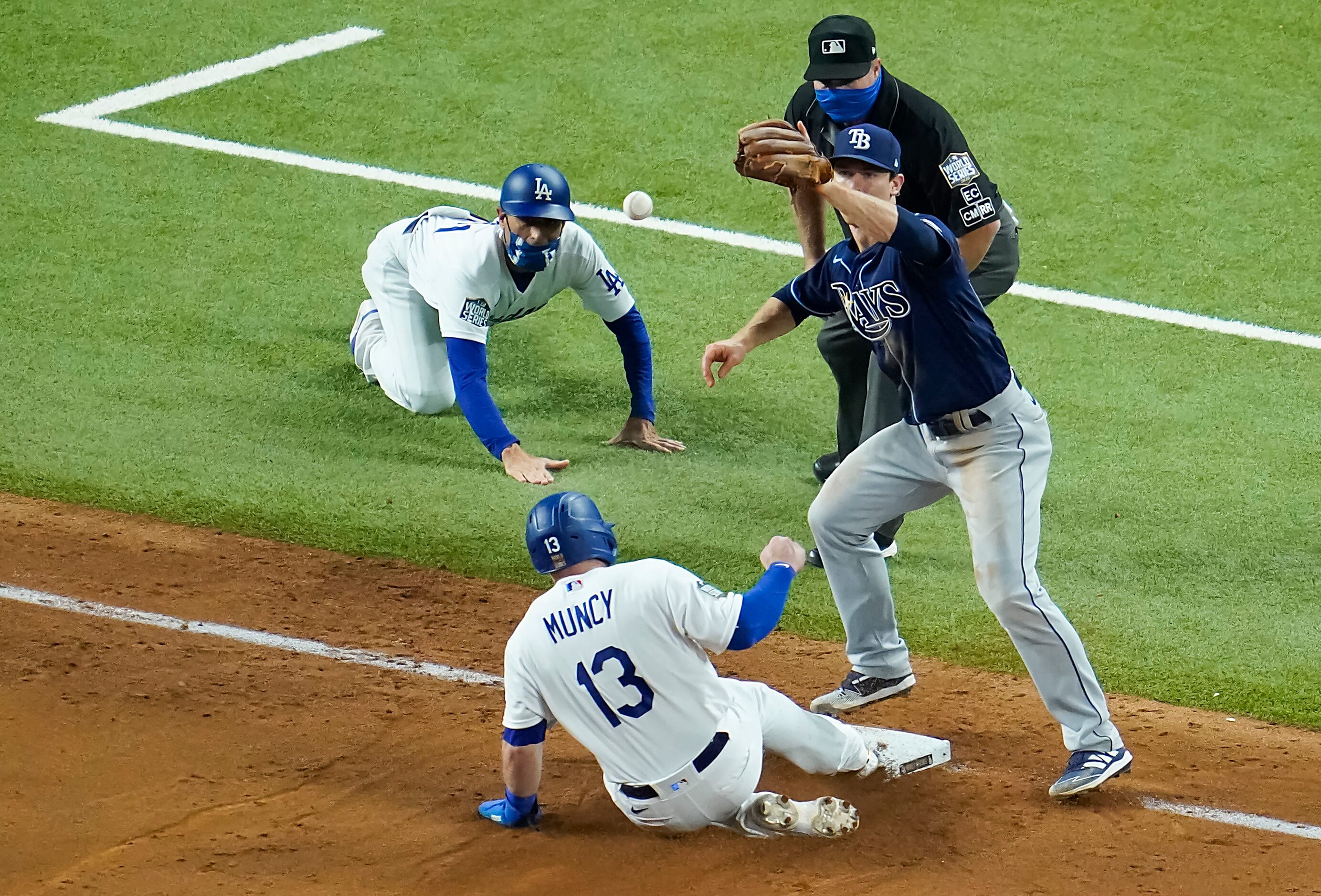 Los Angeles Dodgers first baseman Max Muncy (13) is safe at third after tagging up on a...