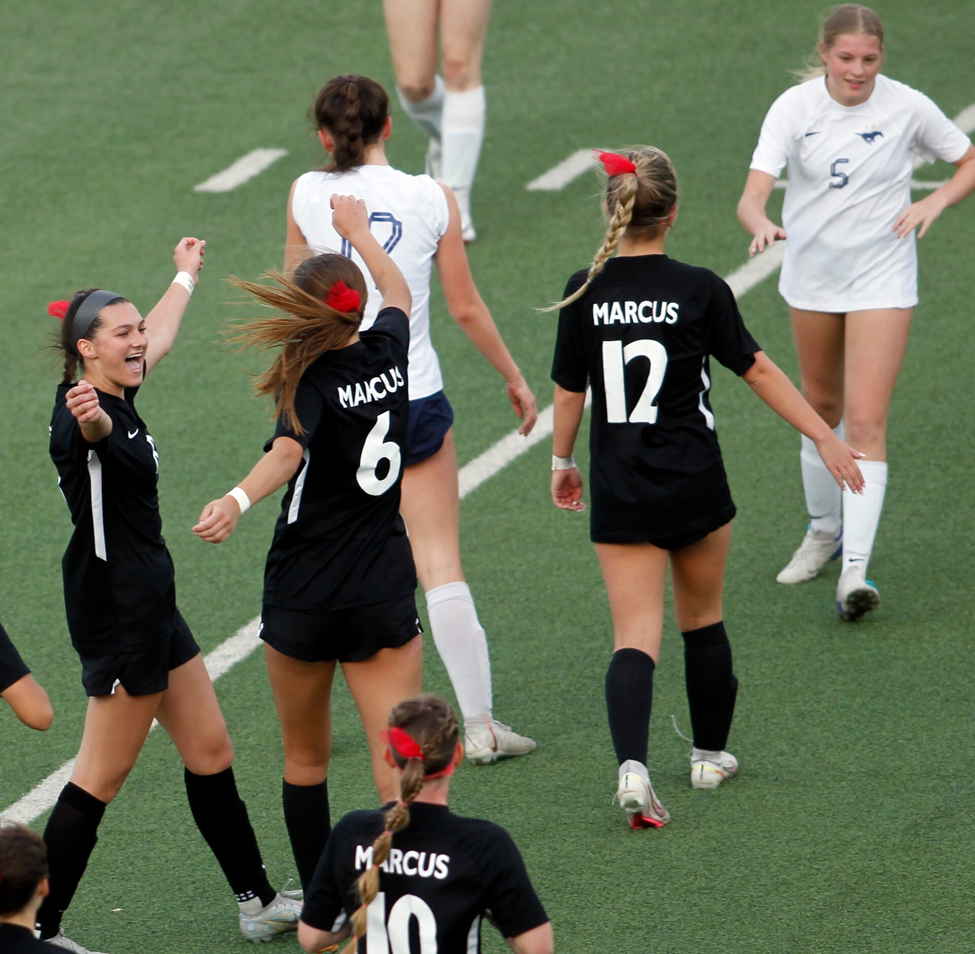 Flower Mound Marcus players Emma Fioretti (8), left, celebrates with Ava Young (6) following...