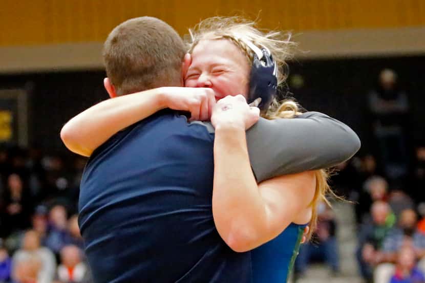 Hadley Snyder of Frisco Reedy High School embraces her coach after winning her 138 division...
