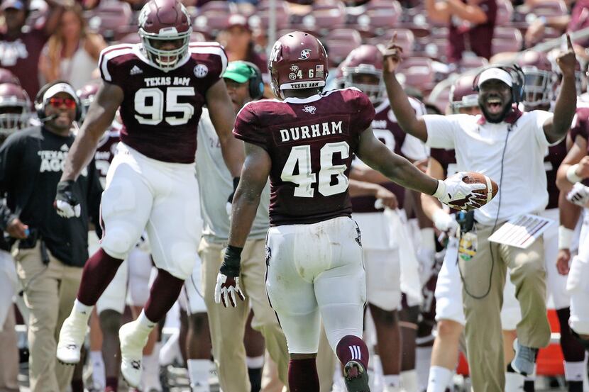 Texas A&M Aggies defensive lineman Landis Durham (46)  is greeted by a jubilant sidelines...