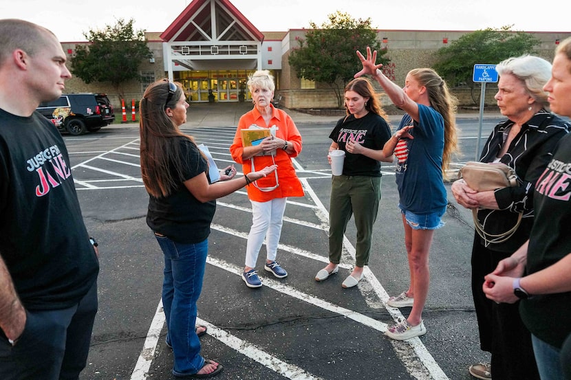 State Board of Education member Pat Hardy (center, wearing orange) talks with members of the...