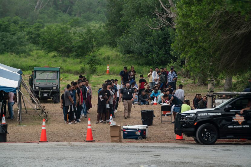 Migrants who recently crossed the border between the U.S. and Mexico are seen in...