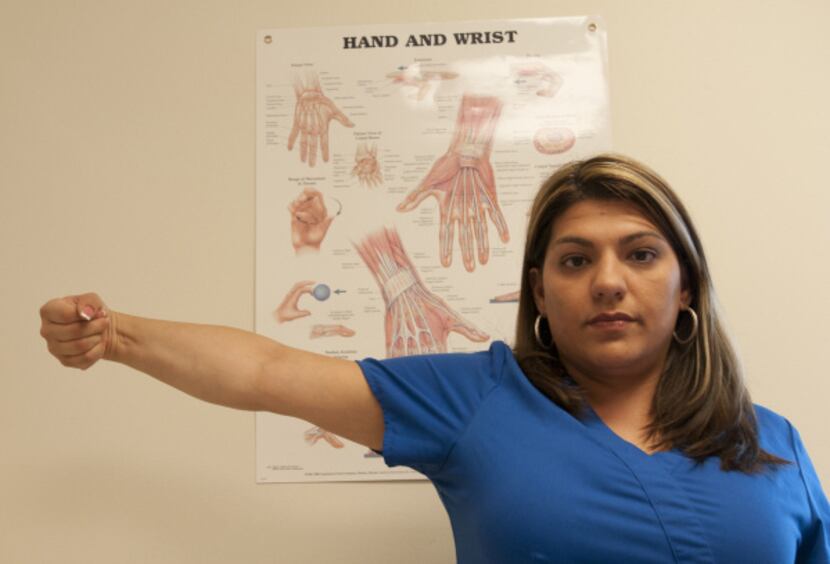 Brenda Alvarez demonstrates Step 9 of an arm exercise to alleviate hand pain.