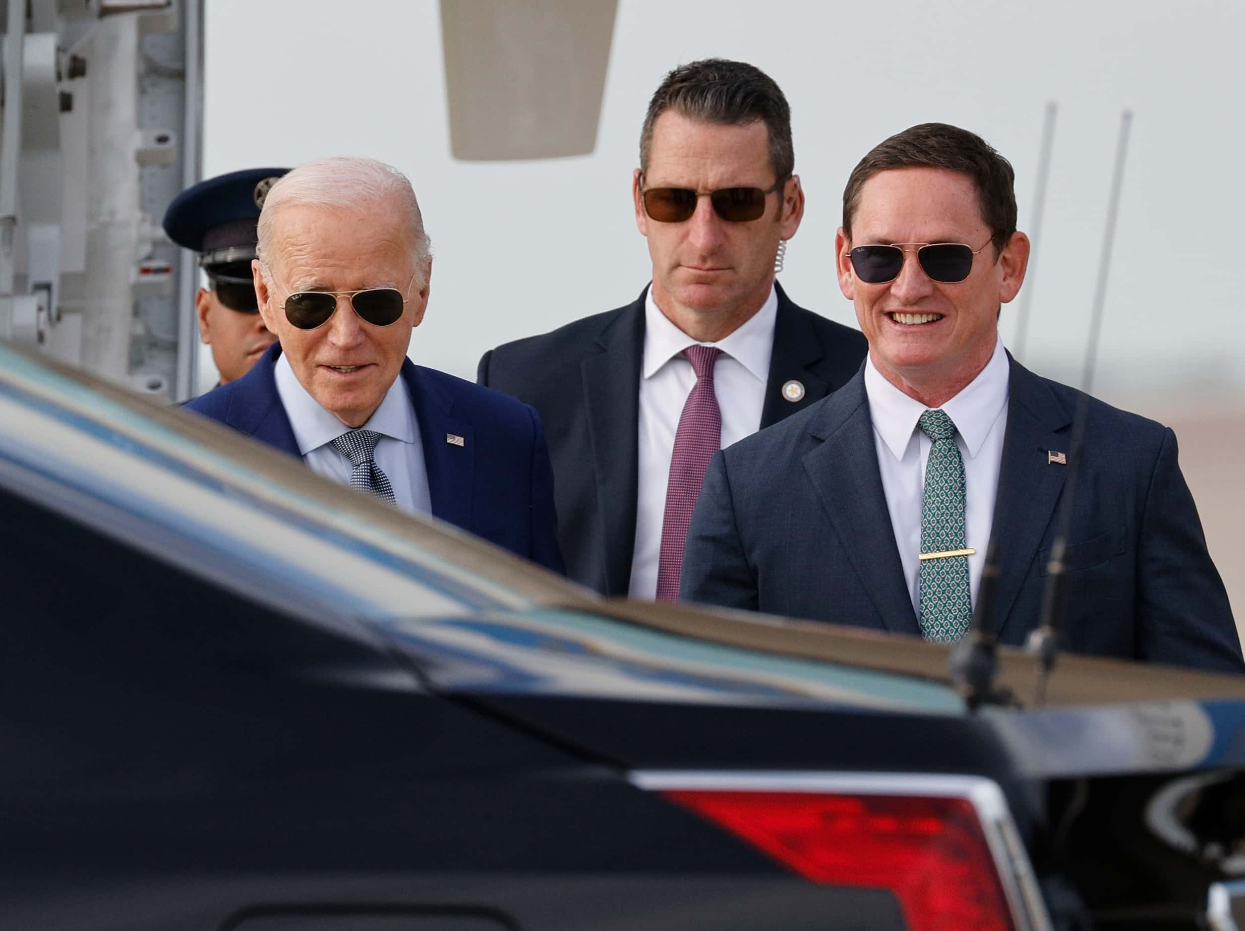 President Joe Biden, left, walks to his limousine with Dallas County Judge Clay Jenkins,...