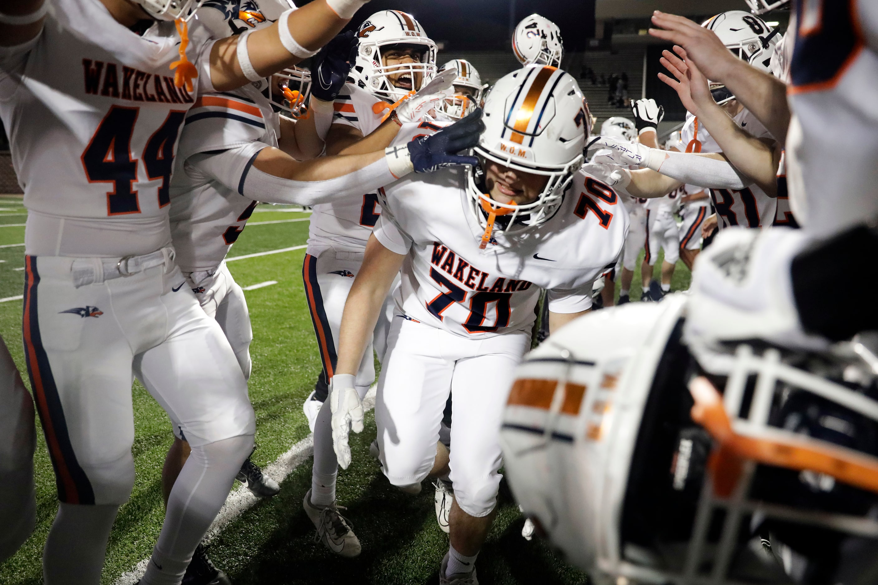 Frisco Wakeland’s Robert Altman (70) dances through a tunnel created by his teammates as...