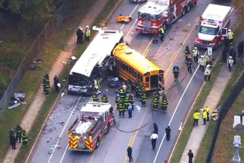 Emergency personnel work at the scene of a fatal crash between a school bus and commuter bus...
