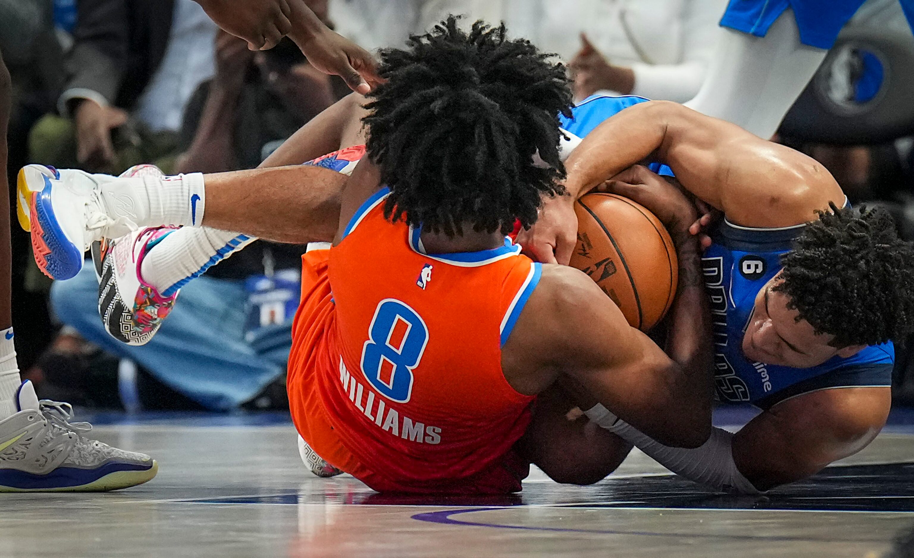 Dallas Mavericks guard Josh Green wrestles for a loose ball with Oklahoma City Thunder...