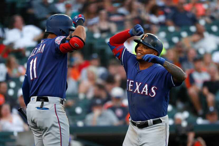 Texas Rangers' Willie Calhoun, right, celebrates his solo home run with Ronald Guzman in the...