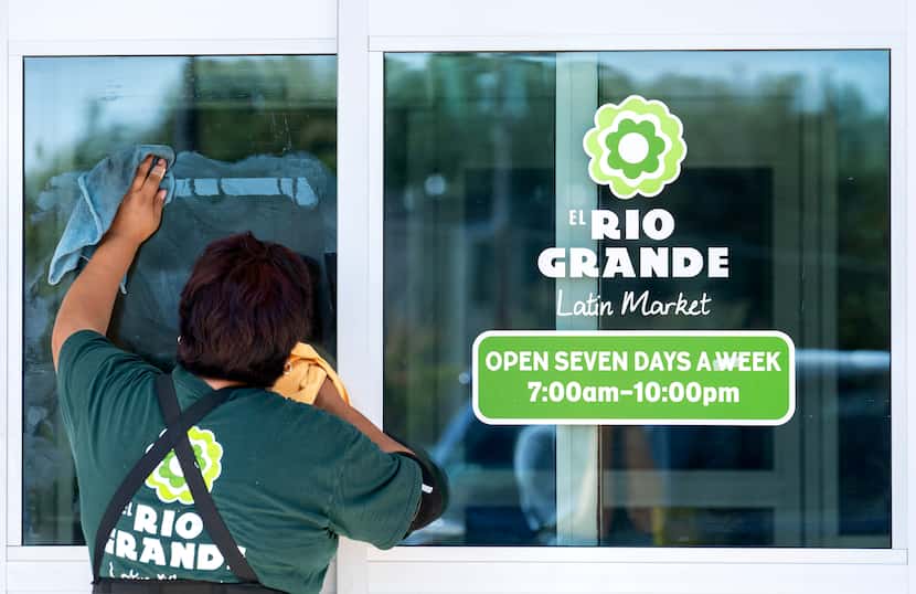 Silvia Alcantara cleans the front doors of the newest El Rio Grande Latin Market grocery...