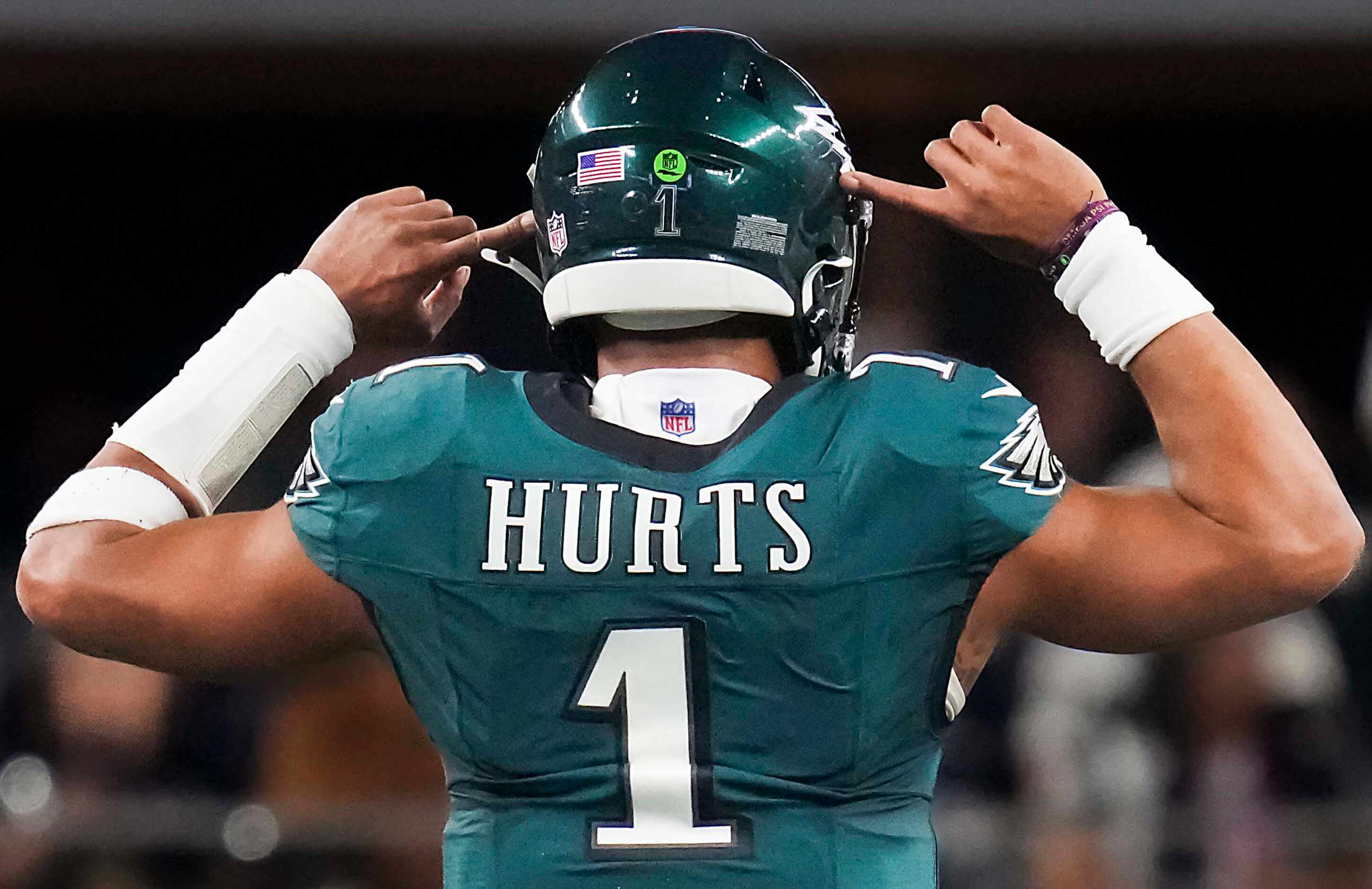 Philadelphia Eagles quarterback Jalen Hurts points to his ears before the Eagles were...