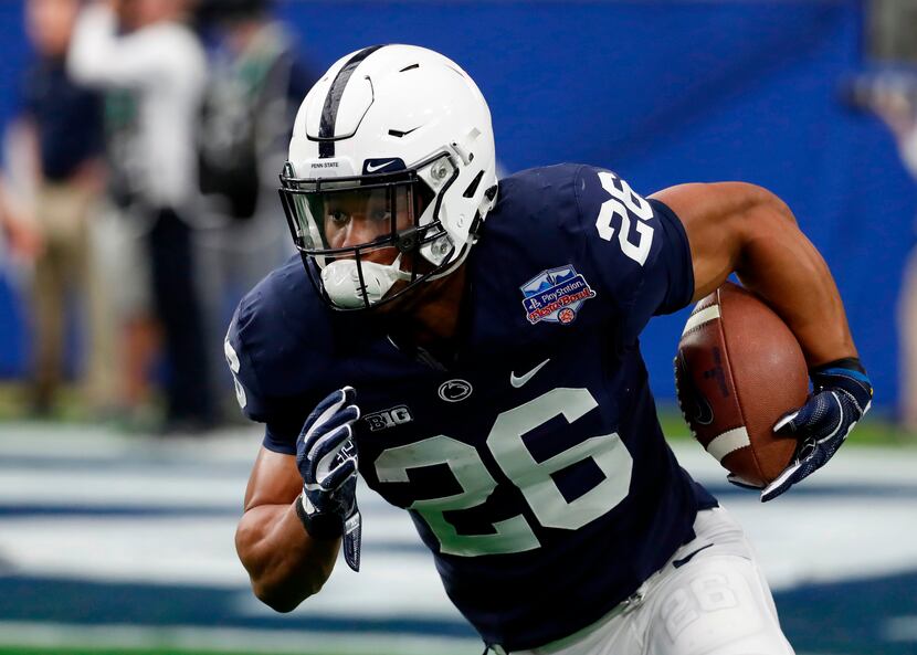 FILE - In this Dec. 30, 2017 file photo Penn State running back Saquon Barkley (26) runs the...