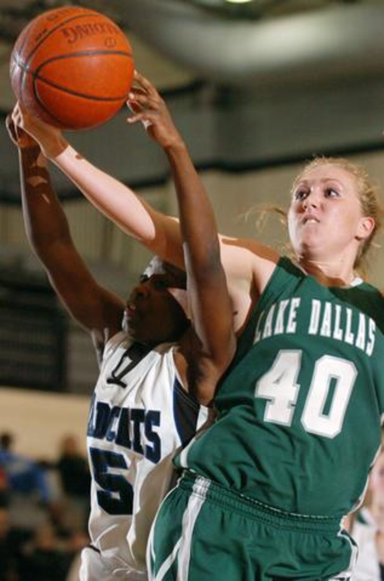 Guyer's Jasmine Badiru (5) and Lake Dallas' Kate Schabel (40) reach for a rebound on Friday,...