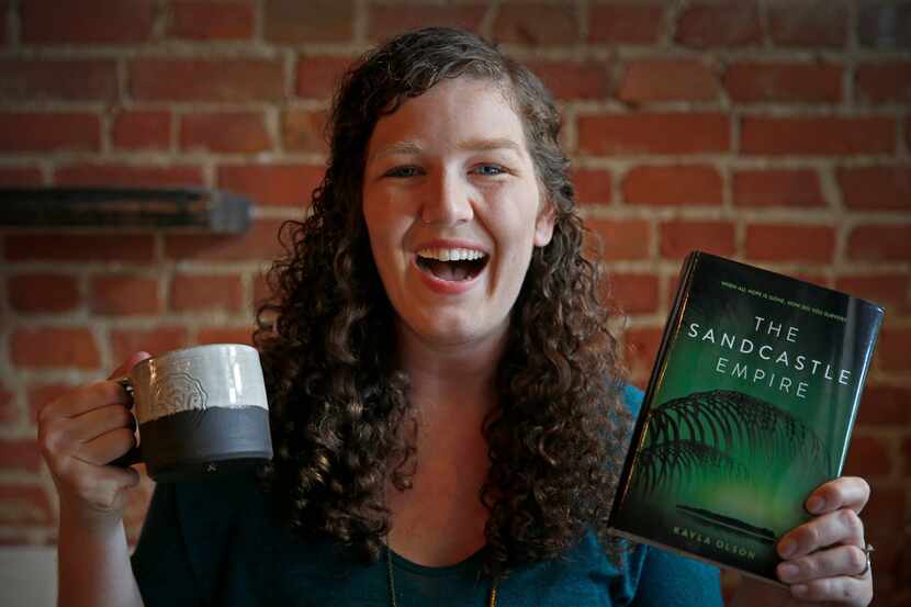 Author Kayla Olson with a coffee mug and her book,  The Sandcastle Empire,  at West Oak...