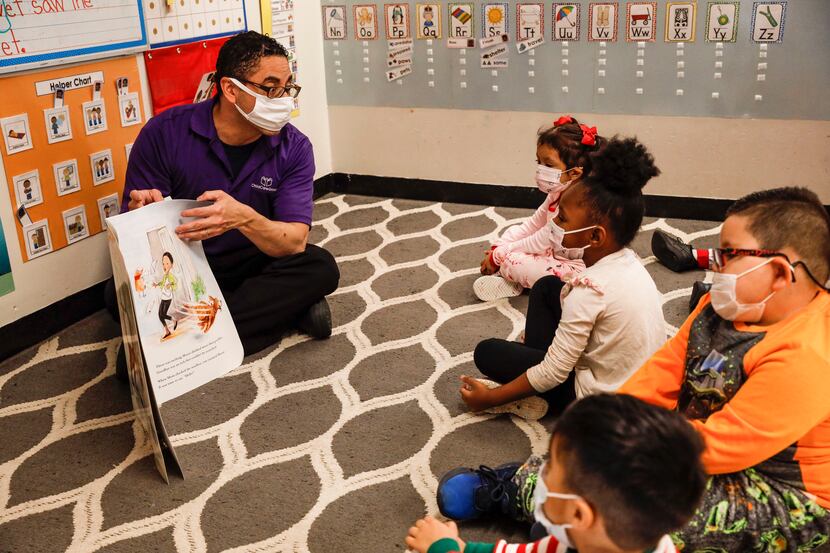 Juan Delgado, a preschool teacher at Child Care Group's Landauer Center, reads a book to...