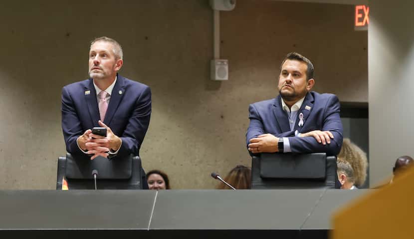 Dallas City Council members Chad West (left) and Adam Bazaldua 
listened to a discussion...