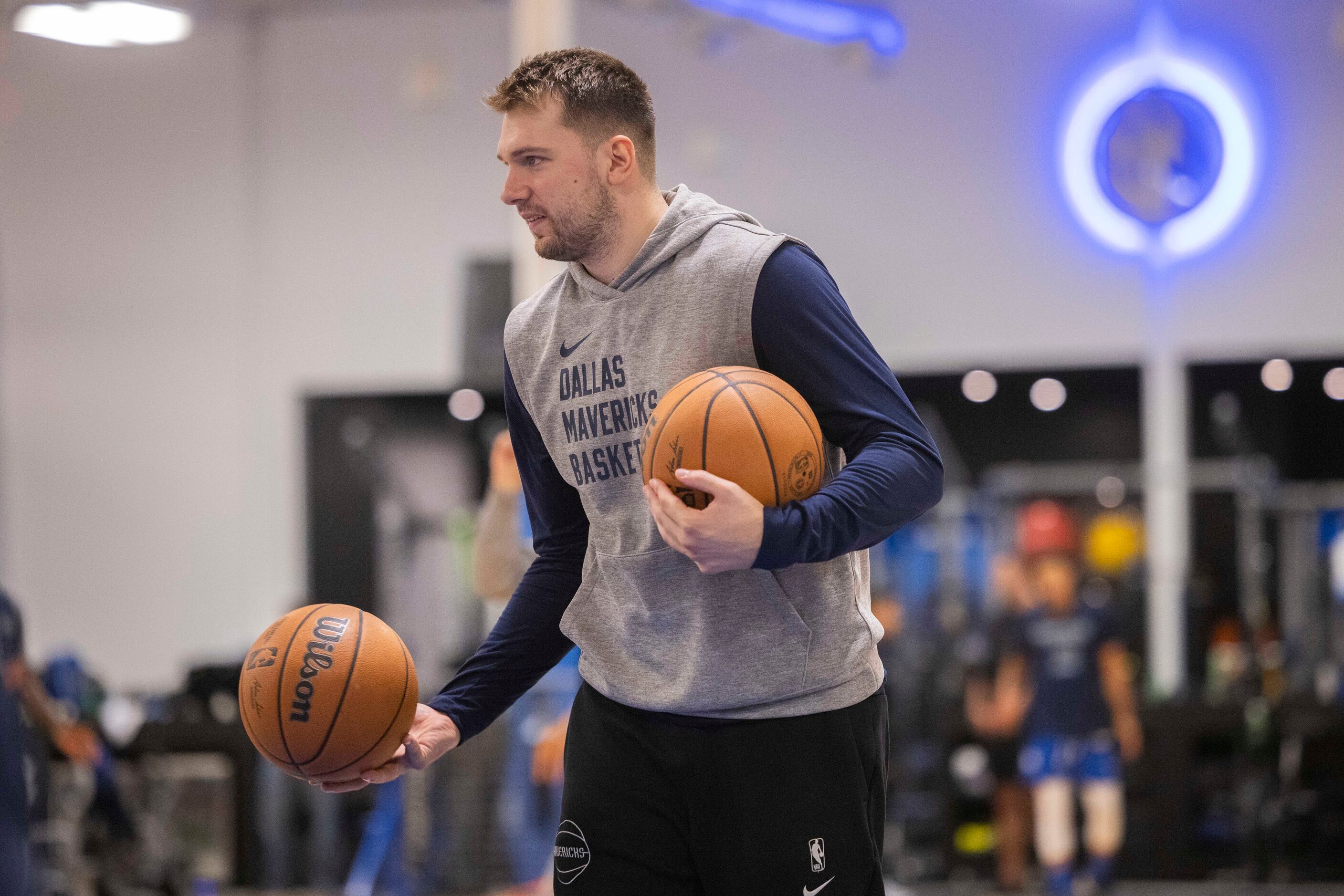 Dallas Mavericks guard Luka Dončić (77) carries two basketballs during practice at the...