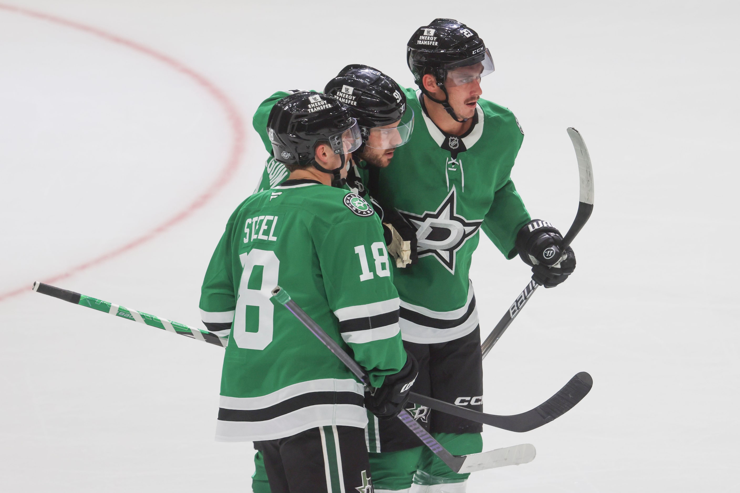 Dallas Stars center Tyler Seguin (center) gets congratulated by center Sam Steel (18) and...