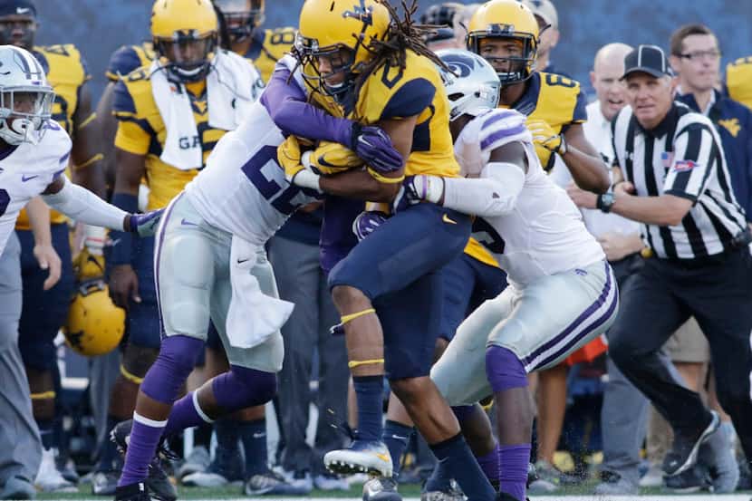 West Virginia running back Justin Crawford (25) is tackled by Kansas State defensive back...