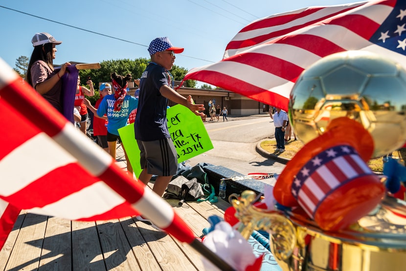 Luis Rivera Jr., 10, center, rides in the back of a trailer during this year's Independence...