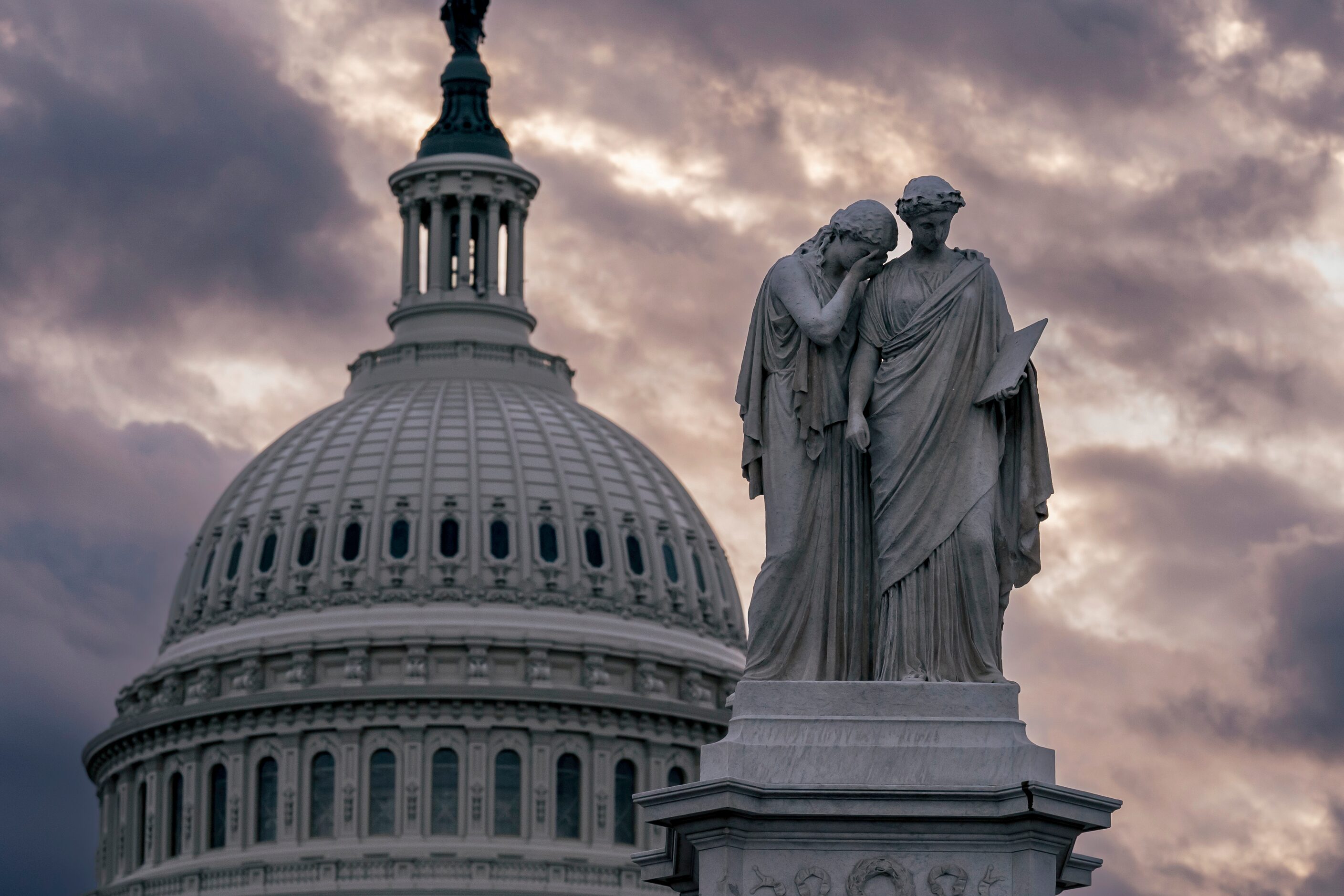 The Peace Monument and the Capitol Dome are seen amid cloudy skies as the House of...