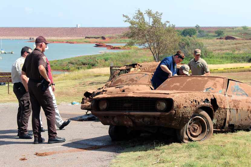 In this Sept. 17, 2013, photo, officials investigate the scene at Foss Lake, Okla. where two...