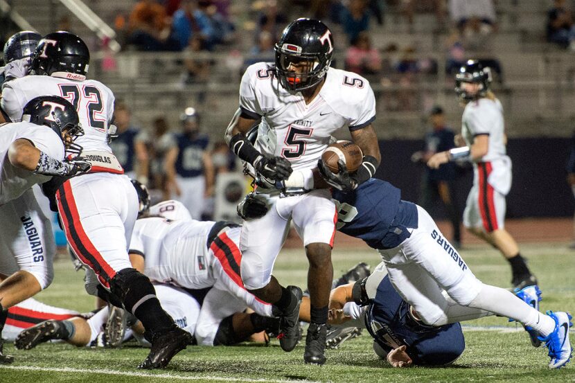 Euless Trinity senior running back Greg Garner (5) breaks the tackle of Flower Mound senior...