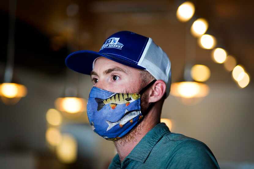Bar manager Brett Martin wears a fish-themed face mask at TJ's Seafood restaurant on...