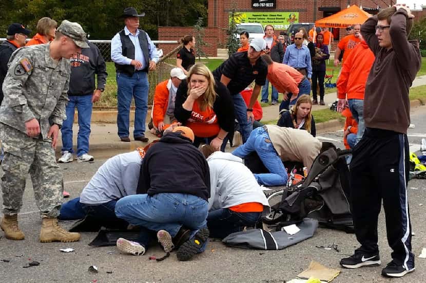  Bystanders help the injured after a vehicle crashed into a crowd of spectators during the...