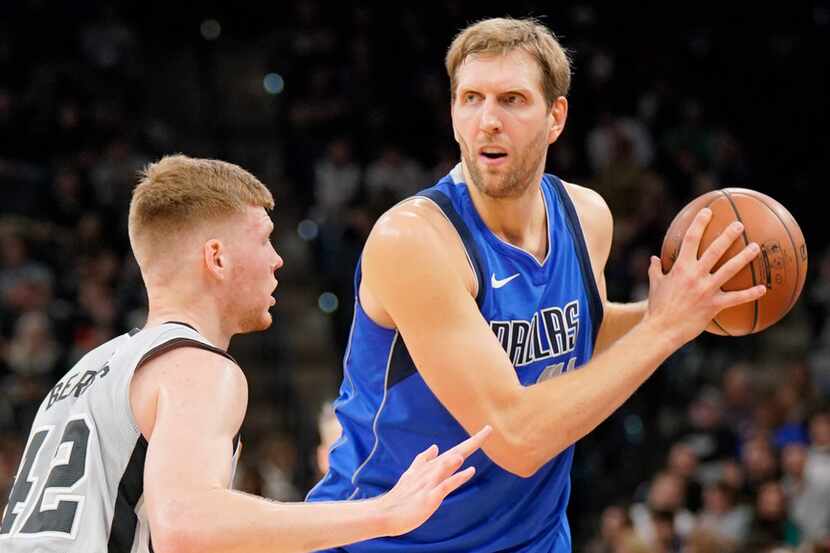 Dallas Mavericks forward Dirk Nowitzki, right, looks to pass around San Antonio Spurs...