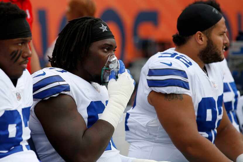 Dallas Cowboys defensive end Demarcus Lawrence (90) takes in oxygen on the sidelines in the...
