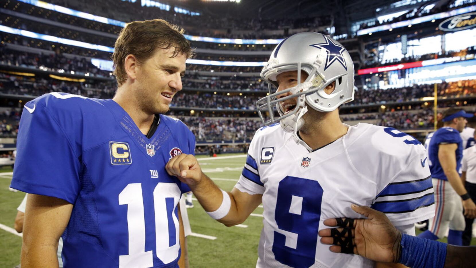 Dallas Cowboys quarterback Tony Romo (9) and New York Giants quarterback Eli Manning (10)...