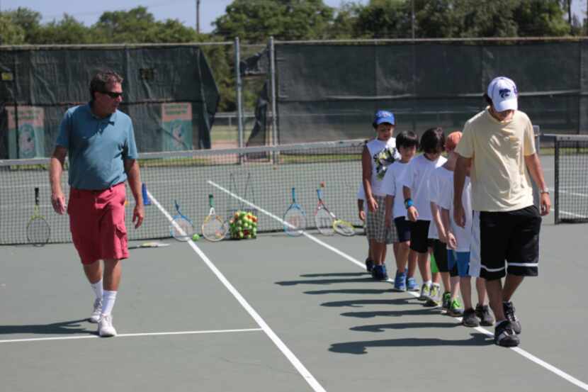 A tennis coach at Dallas ISD’s George Bannerman Dealey Montessori in North Dallas, James...