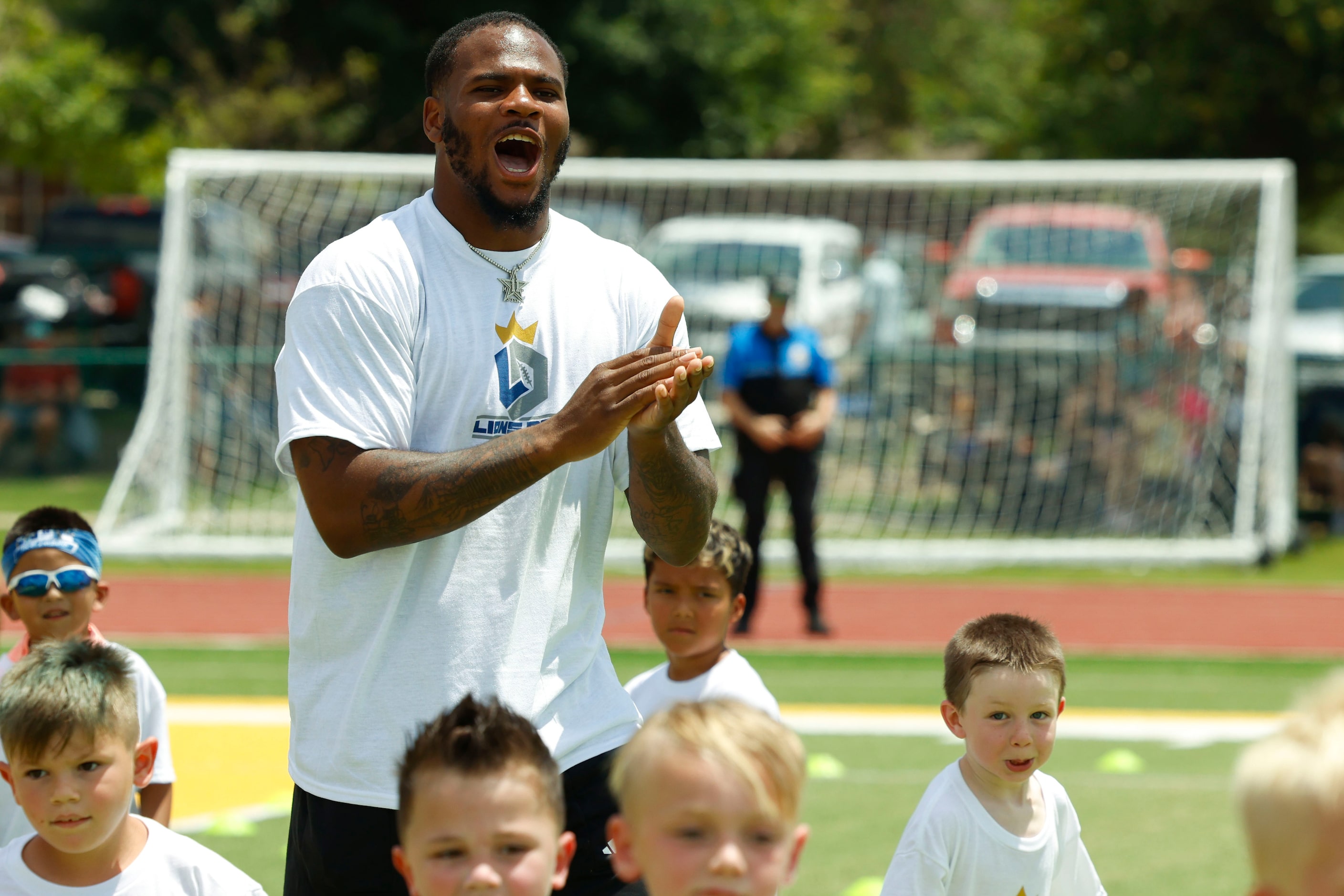 Dallas Cowboys linebacker Micah Parsons reacts towards a catch as he interacts with young...