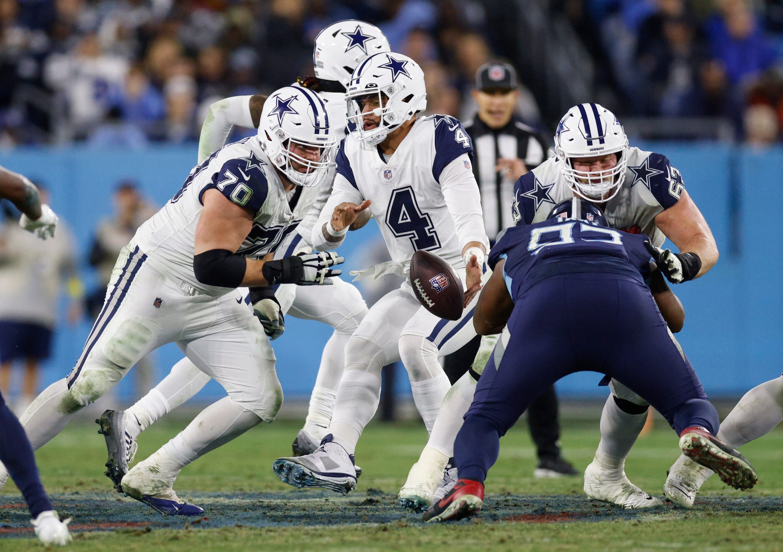 Dallas Cowboys quarterback Dak Prescott (4) fumbles the snap from center Tyler Biadasz (63)...