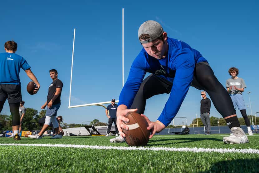 Maxwell Johnston, 17, of LD Bell High School, works on his long snap technique during a...