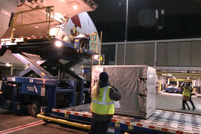 American Airlines workers at Chicago O'Hare International Airport load...