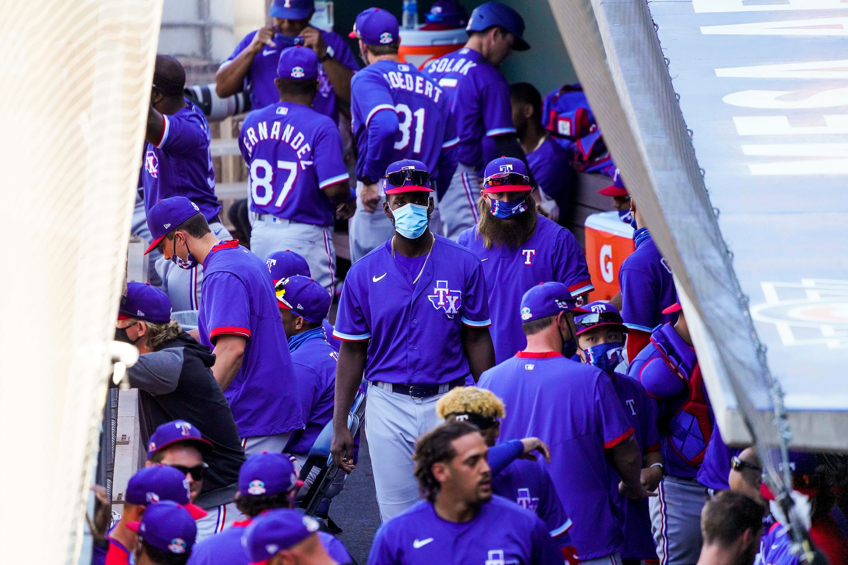 Texas Rangers infielder Sherten Apostel wears a face mask in the dugout during the third...