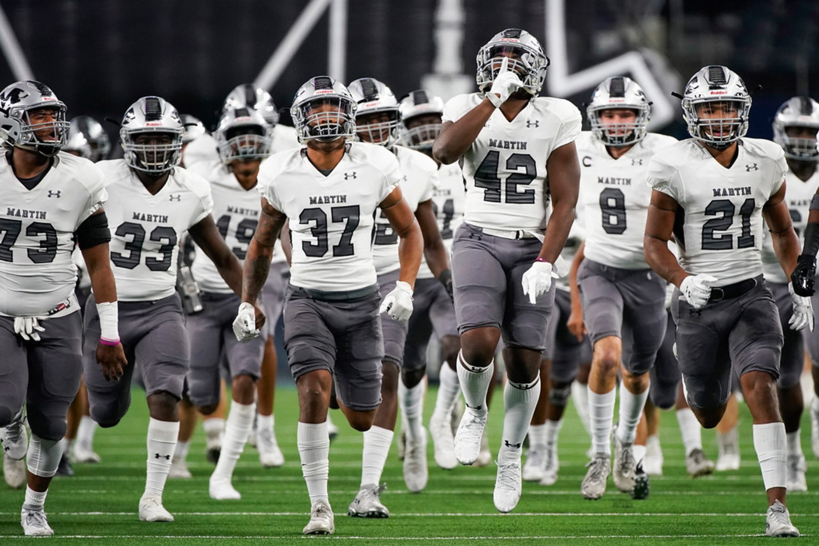 Arlington Martin linebacker Julian Johnson (42) leads his team onto the field to face...