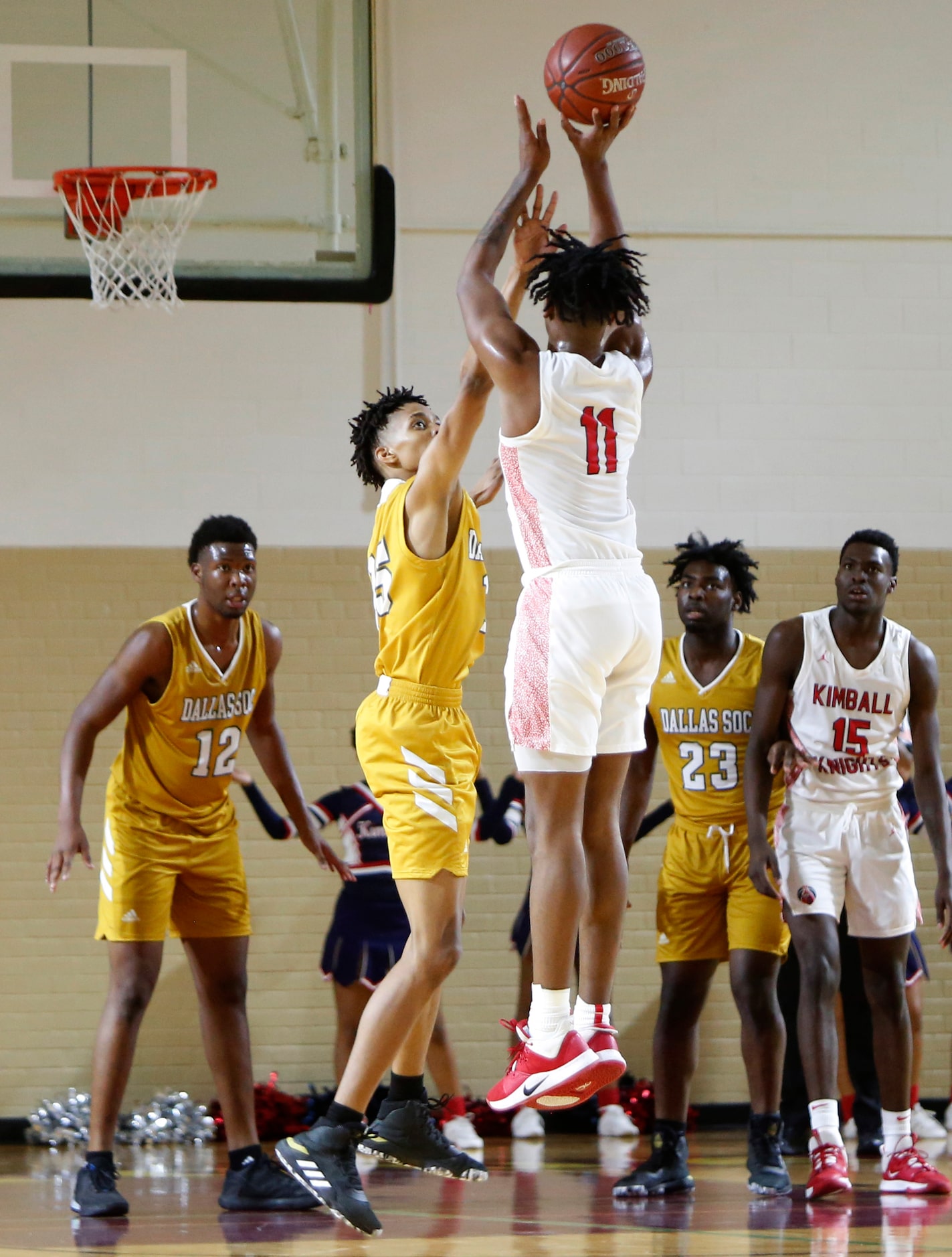 Dallas Kimball's Cory Reynolds (11) shoots and scores a 3-pointer over the defense of Dallas...