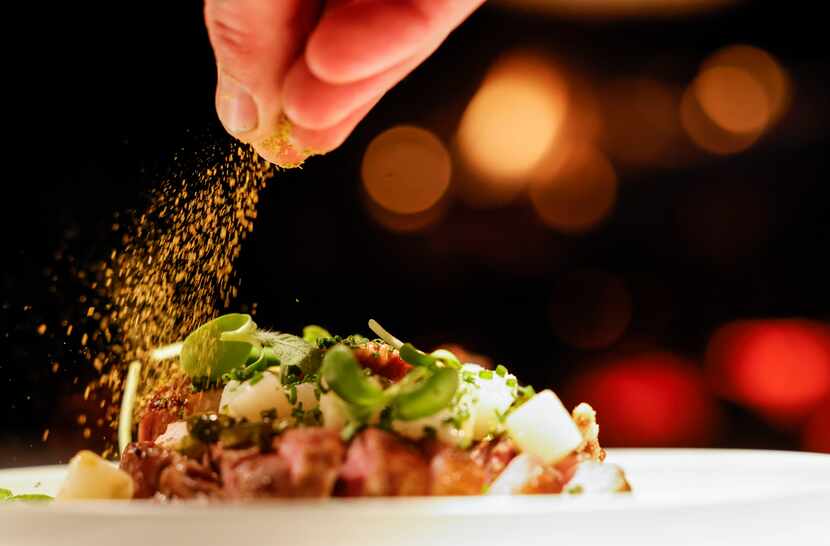 Chef Ross Demers garnishes a pork chops at Cry Wolf in Dallas.