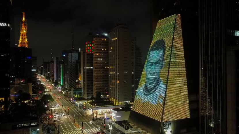 En esta imagen tomada con un dron, se ve la cara de Pelé proyectada en el edificio de la...