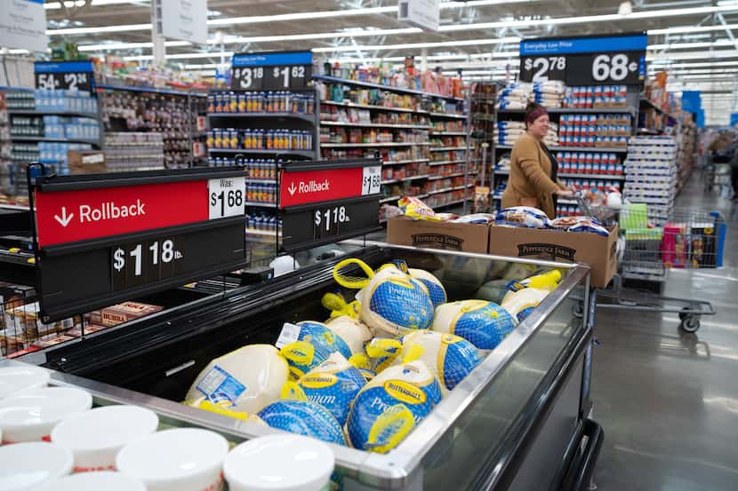 A shopper pushes her cart by the Butterball turkeys that were discounted at Walmart in...