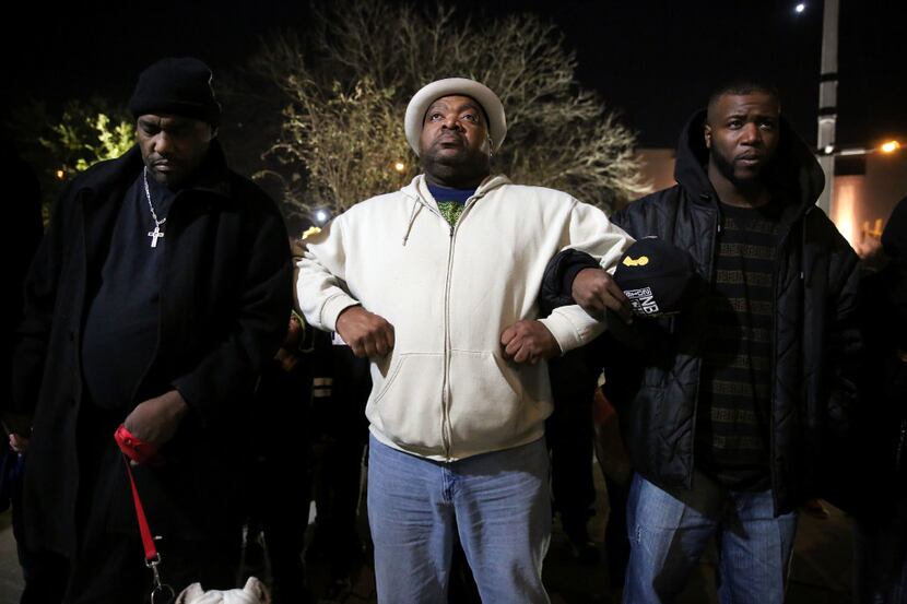 From left: Protesters Ernest Walker, Cecil Callier and Mdot White joined in prayer outside...