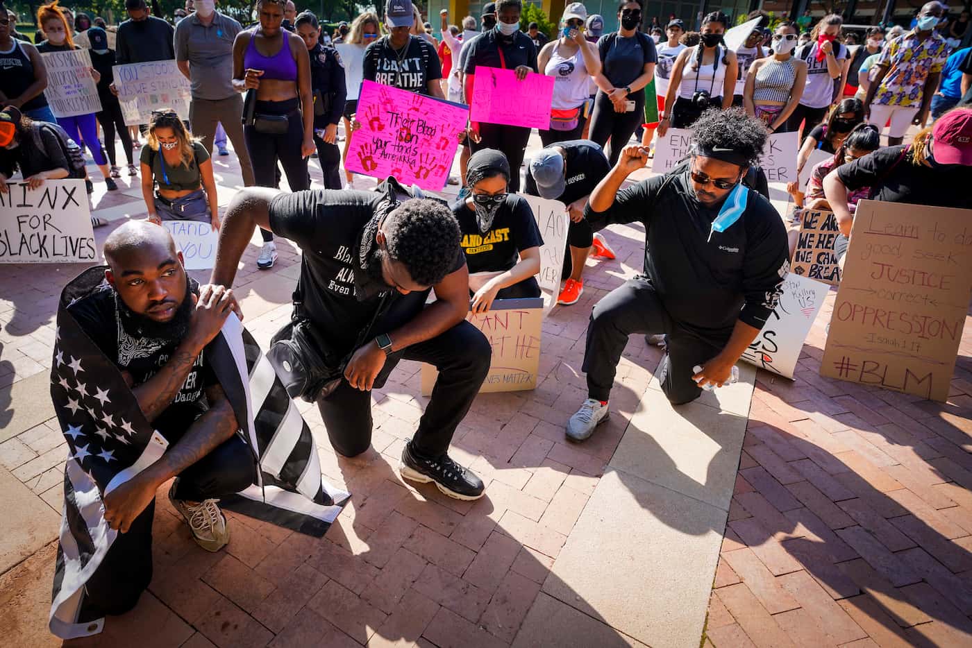 Jacob Clayton (left) kneels for a moment of silence with Brandon Moore during a protest on...