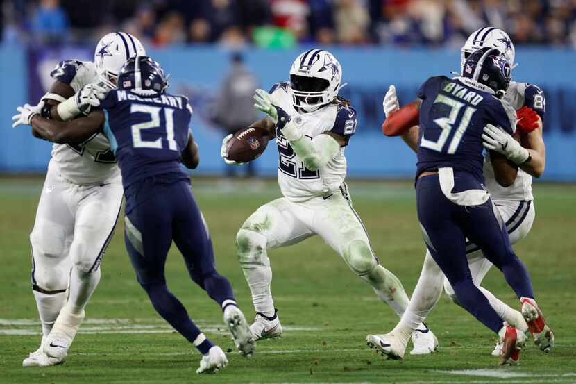 Dallas Cowboys running back Ezekiel Elliott (21) runs the ball between a pair blocks during...